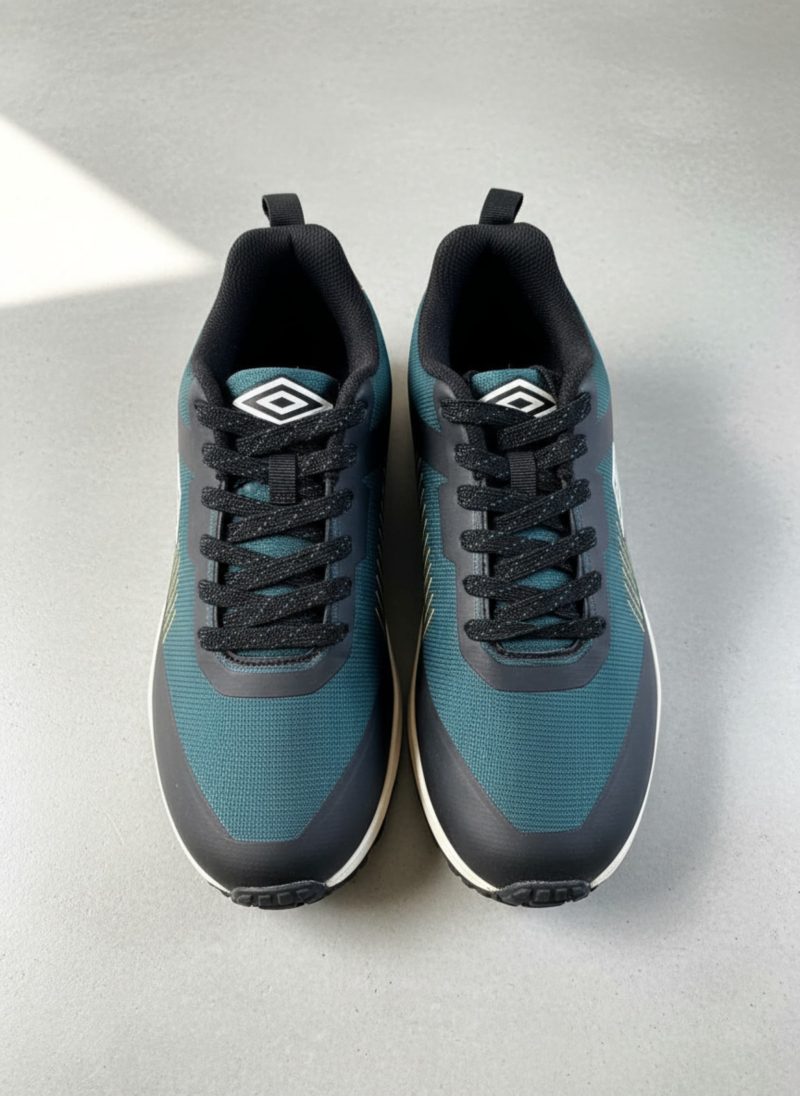 Pair of Umbro blue and teal running shoes with yellow design lines on a wooden surface