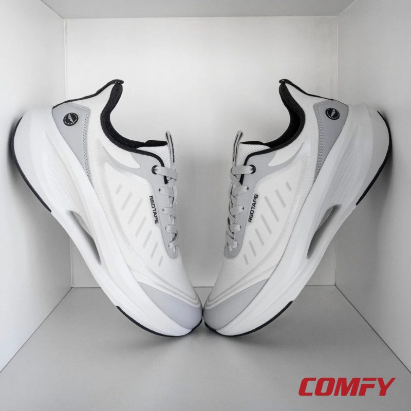 Pair of Red Tape white and grey athleisure sports shoes for men displayed in a modern white box.