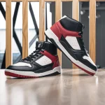 Red Tape men's black, red, white high-neck casual sneakers on a wooden table with slatted background, lifestyle shot.