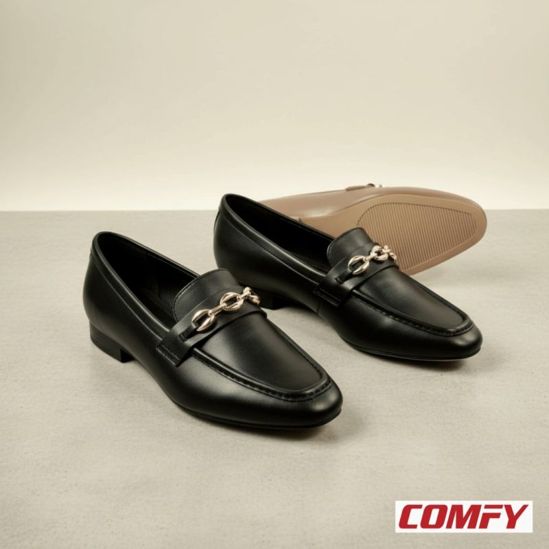 Two black chain loafers in the foreground, with a brown chain loafer in the background, all on a light gray surface.