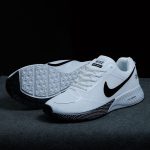 Pair of AeroFlex white running shoes on dark surface, showing side profile, black swoosh, and detailed sole pattern.