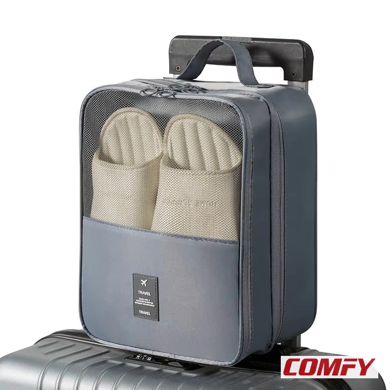Grey TravelEase waterproof shoe bag attached to a silver suitcase handle, showcasing beige slippers through its mesh top, perfect for travel shoe storage.