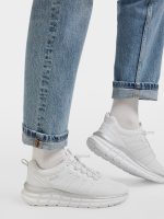 On-foot view of Bench White Slip-On Trainers styled with cuffed blue jeans.