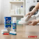 Gloved hands wiping a white sneaker with a cloth next to Biki Shoes Foam Cleaner kit in a laundry room.