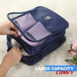 Hands packing sneakers and sandals into a large capacity blue travel shoe bag organizer.