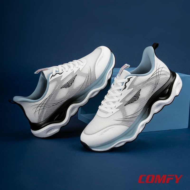 Stylized studio photograph of Red Tape grey athleisure shoes arranged on a blue stage.