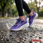 Purple Reebok women's sneakers splashing through a water puddle on wet street